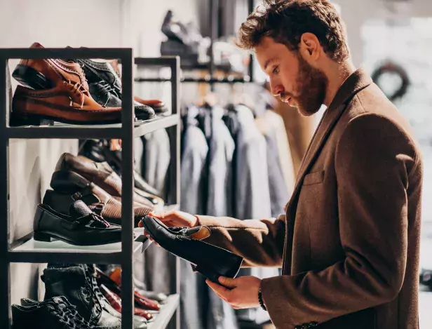 young-handsome-man-choosing-shoes-shop