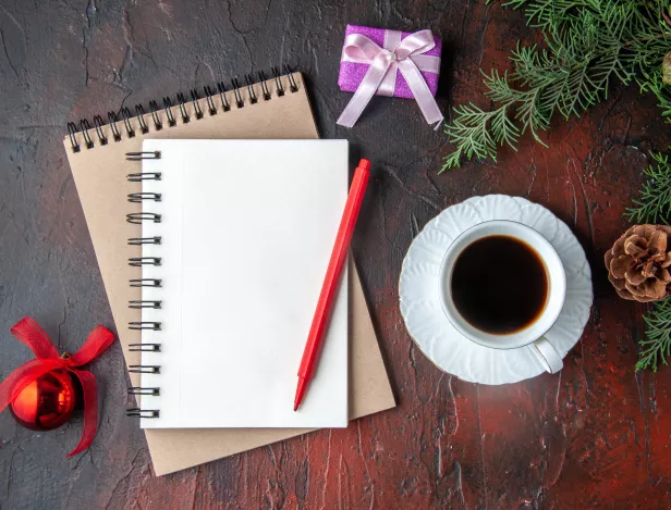 cup-black-tea-fir-branches-decoration-accessories-gift-notebook-with-pen-dark-background