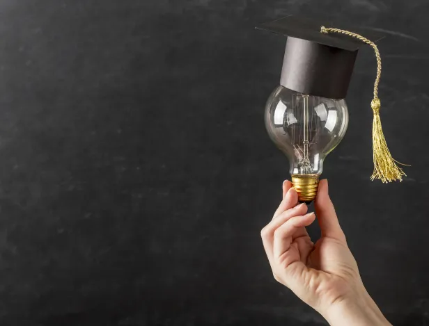person-holding-light-bulb-with-graduation-cap