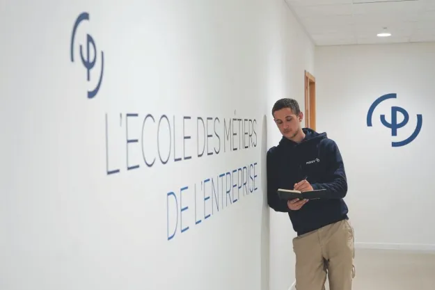 etudiant-poser-sur-le-mur-et-en-train-d-ecrire-sur-un-cahier-pigier
